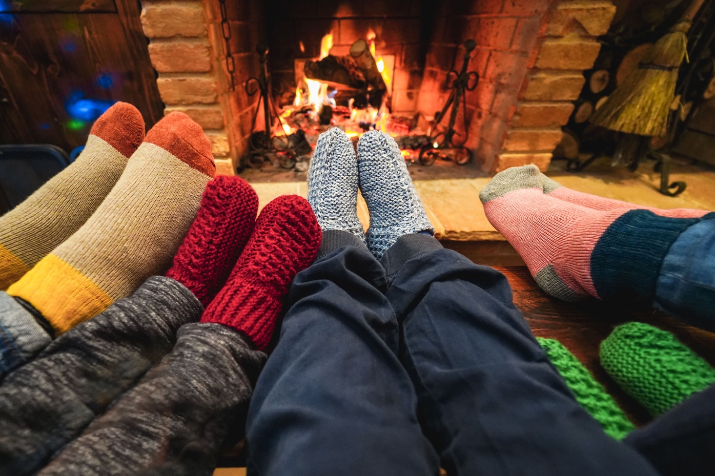 Family wearing colorful socks by fireplace