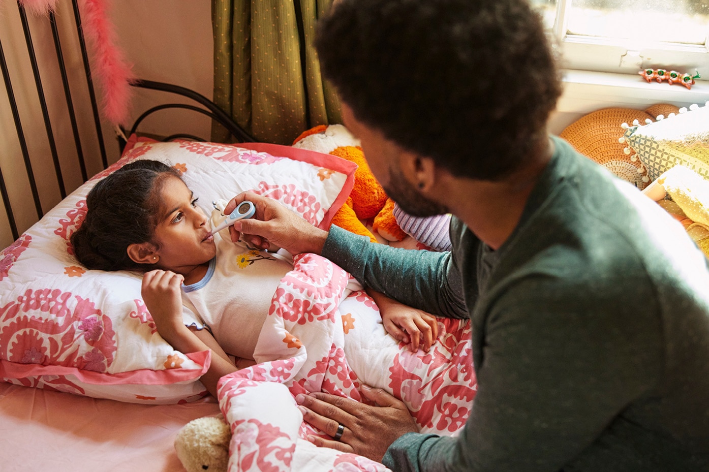 Parent taking sick child’s temperature