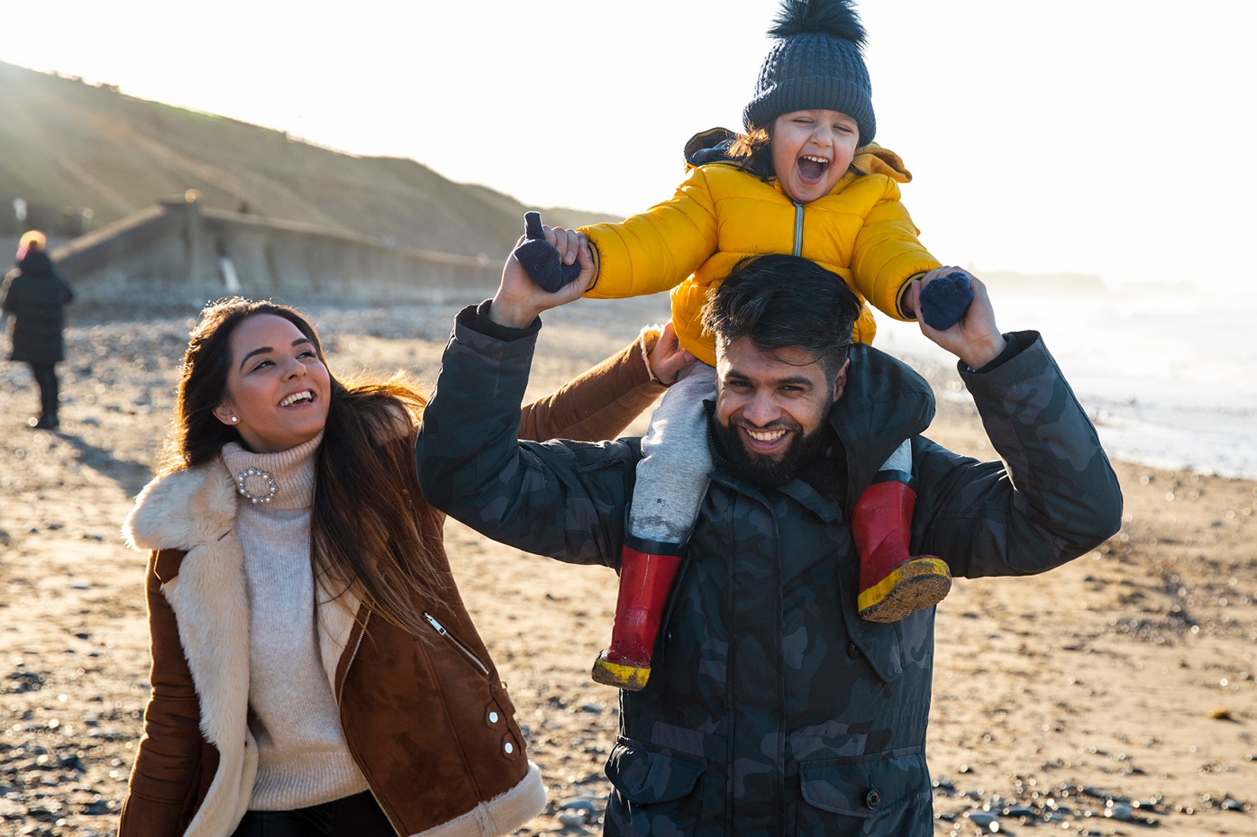 Parents and child waking along bluff overlooking the ocean