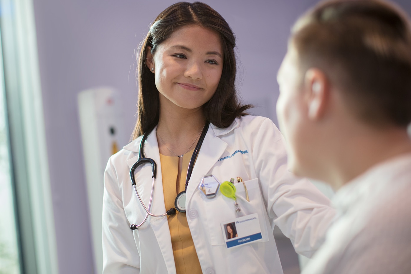 Smiling doctor and patient in an exam room