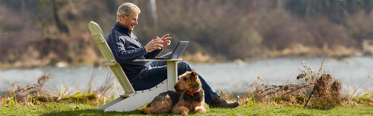 man looking at computer screen next to a dog