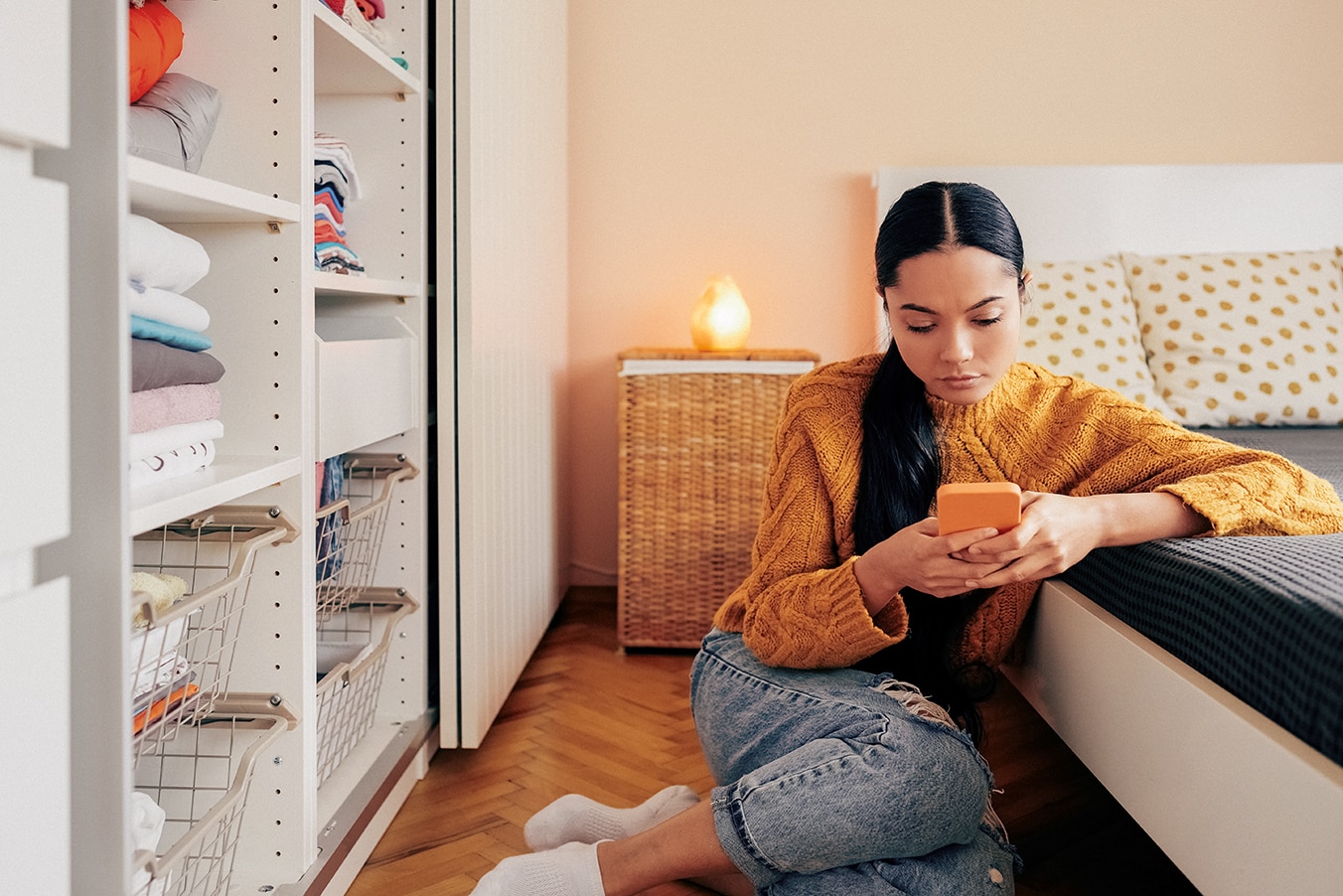  Person focused on phone in bedroom