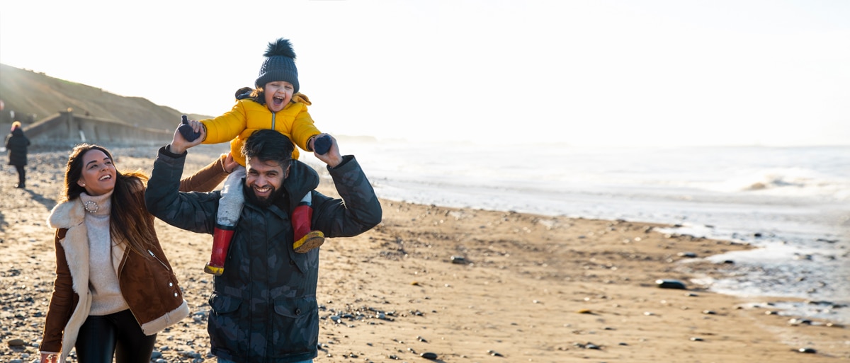 Parents and child walking along bluff overlooking ocean