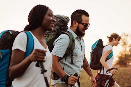 People wearing backpacks and hiking 