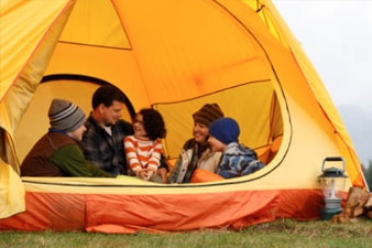 Family sitting in a yellow camping tent