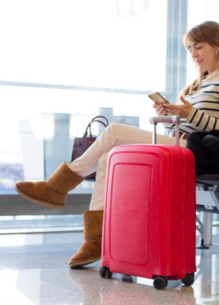 Traveler with a red suitcase waiting at the airport