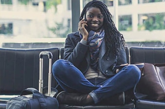 Young person sitting cross-legged and talking on the phone