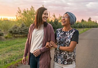 Cancer patient walking outside with young woman