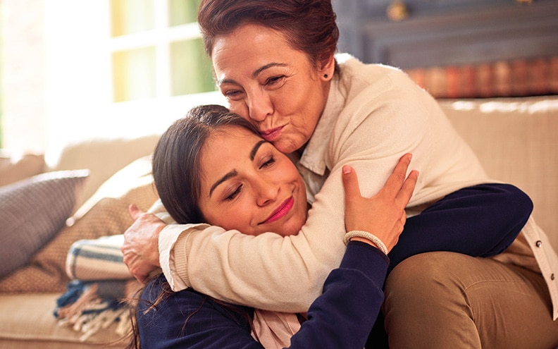 Older person hugging young person