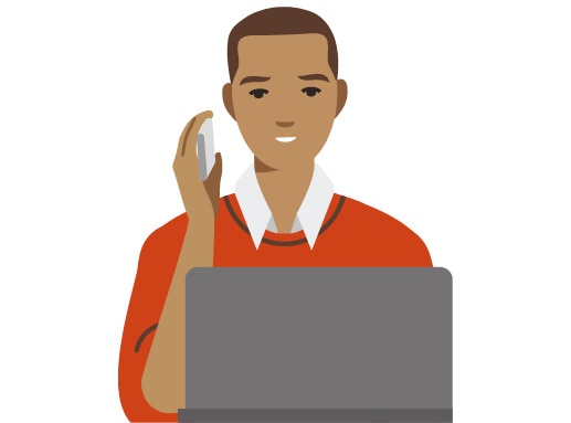 Person in a collared orange shirt talking on the phone in front of a laptop