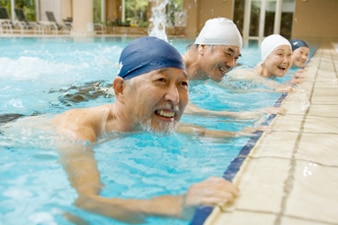 Four people exercising side by side in a pool