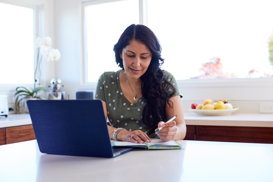 Smiling person using laptop at home