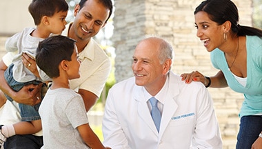Doctor smiling and talking with a boy and his family