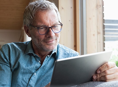 man in glasses works on tablet