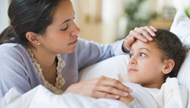Mother checking her son's forehead to see if he has a fever