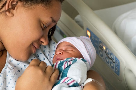 Parent holding their newborn in the hospital