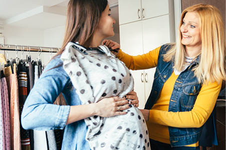 Pregnant person shopping in a clothing store