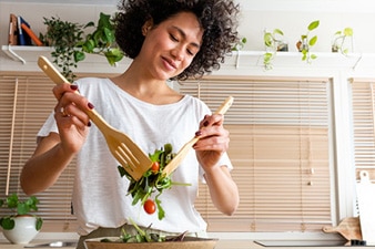 Person tossing a healthy salad