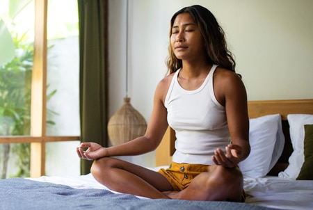 Person meditating in bed