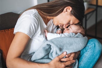 Parent cuddling their newborn baby