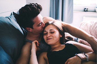 Couple lying together in bed.