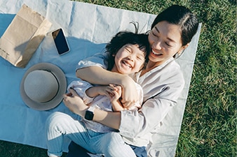 Adult hugging child on a picnic blanket