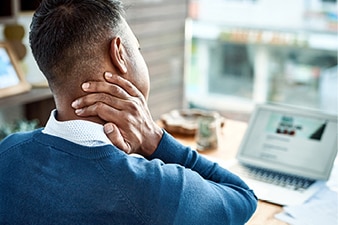 Person rubbing their neck from stress