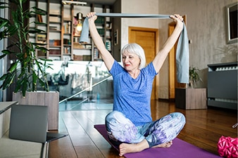 Person sitting cross-legged and doing a stretch