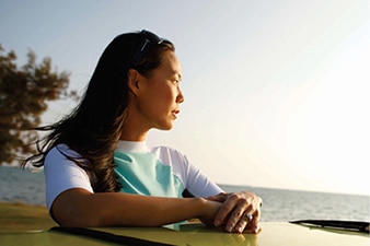 Person with a surfboard looking at the ocean