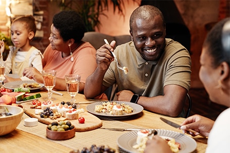 Happy family eating together at dinner table