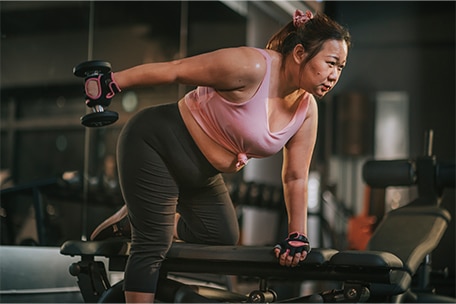 Person strength training with weights at the gym