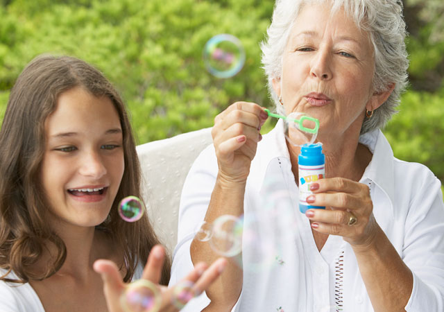 Photo of woman blowing bubbles with girl Photo of woman blowing bubbles with girl