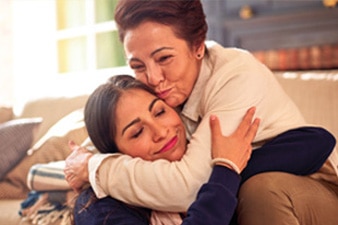 Older person hugging young adult