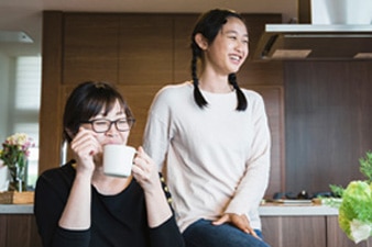 Parent and child relaxing before eating a meal in the kitchen 