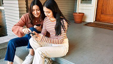 2 teens looking at a smartphone
