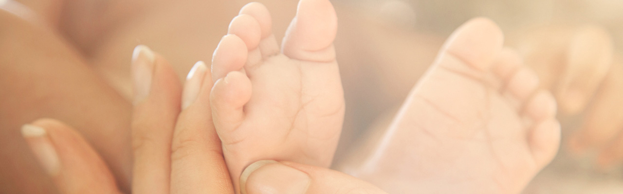 mother holding newborn baby's hand