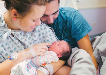 Couple with sleeping newborn baby