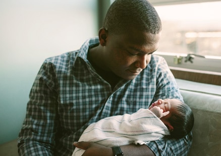 man holding newborn baby