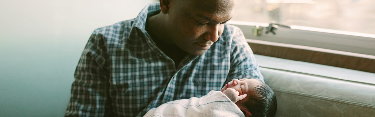 mother holding newborn baby's hand