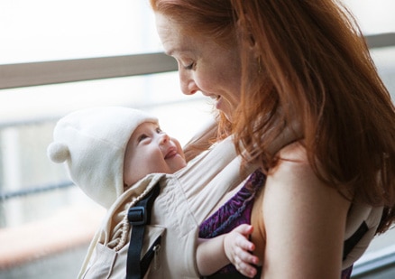 mother holding child in wrap