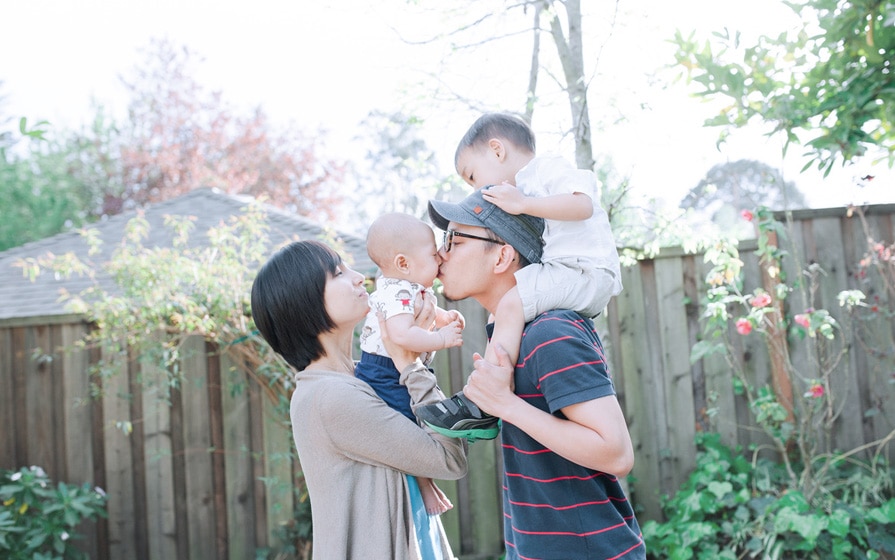 mother, father and two children in back yard