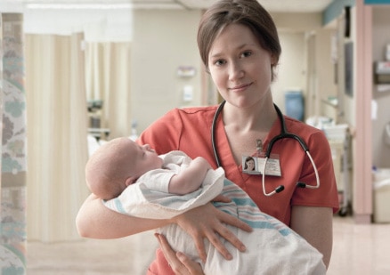 physician holding newborn baby