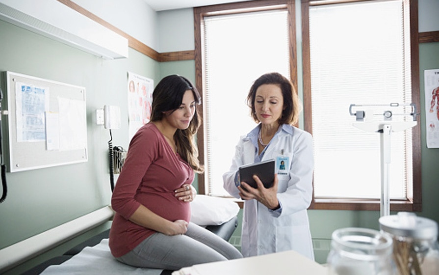 physician with pregnant woman on exam table