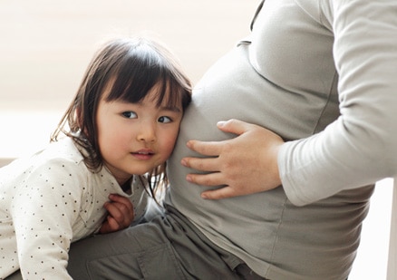 small child with head on mom's belly