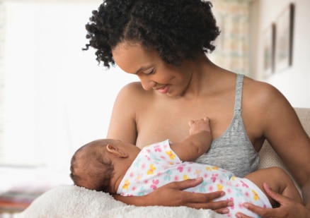 woman breastfeeding newborn baby