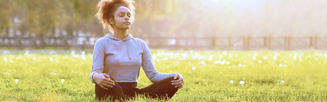 woman on grass meditating