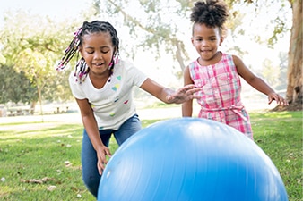 2 children playing with a large ball