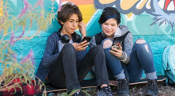 Two teens using their smartphones