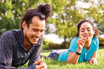 A couple laughing while laying on grass