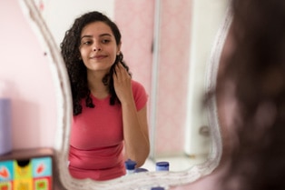 A teen looking in a mirror